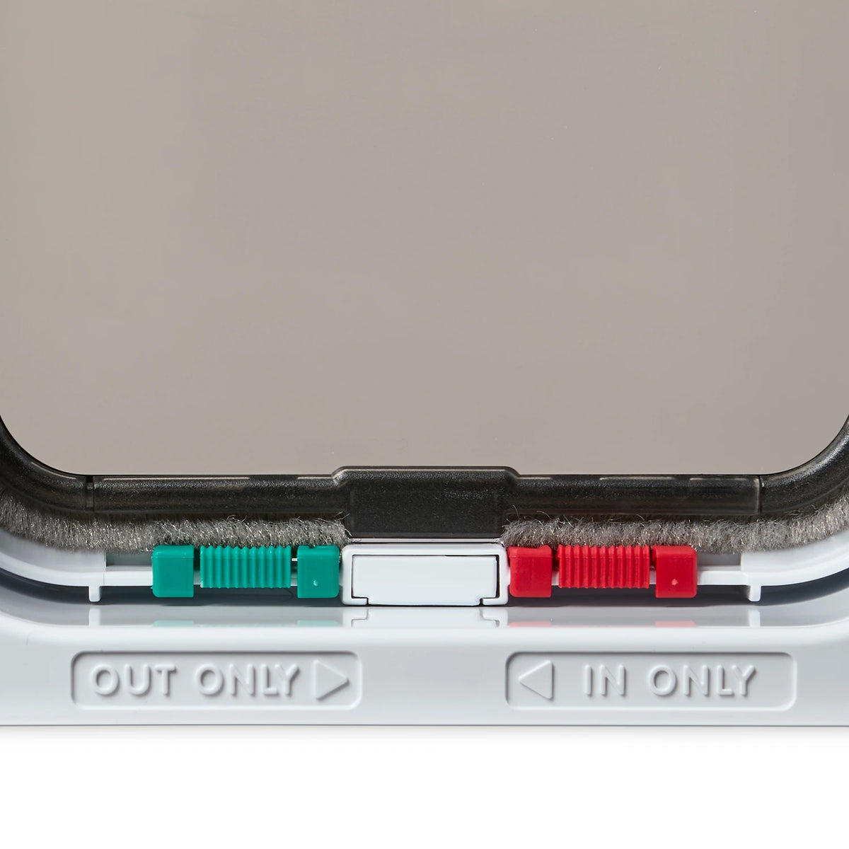 Close-up of the locks on the pet door with 'OUT ONLY' and 'IN ONLY' labels on a white background
