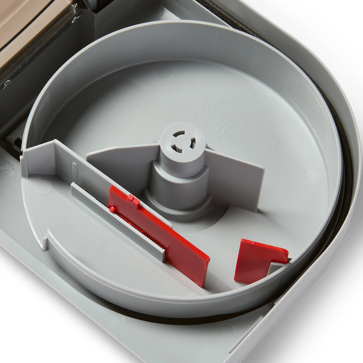 Close-up of the fish food storage compartment with red and grey parts on a white background. 