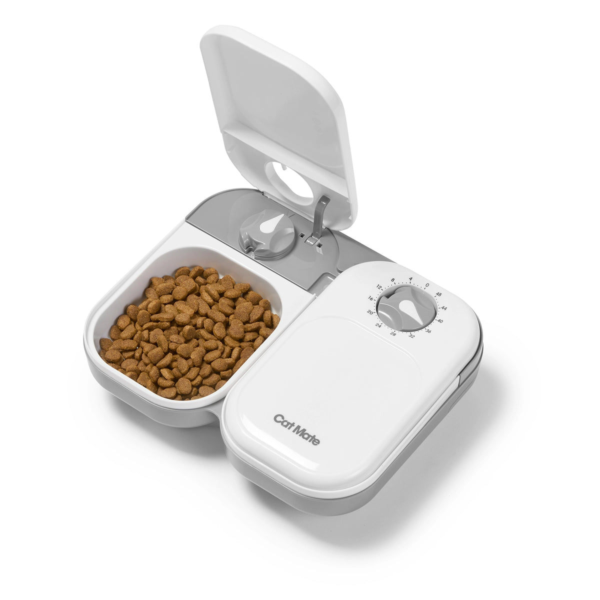 White pet food dispenser with brown kibble on a white background