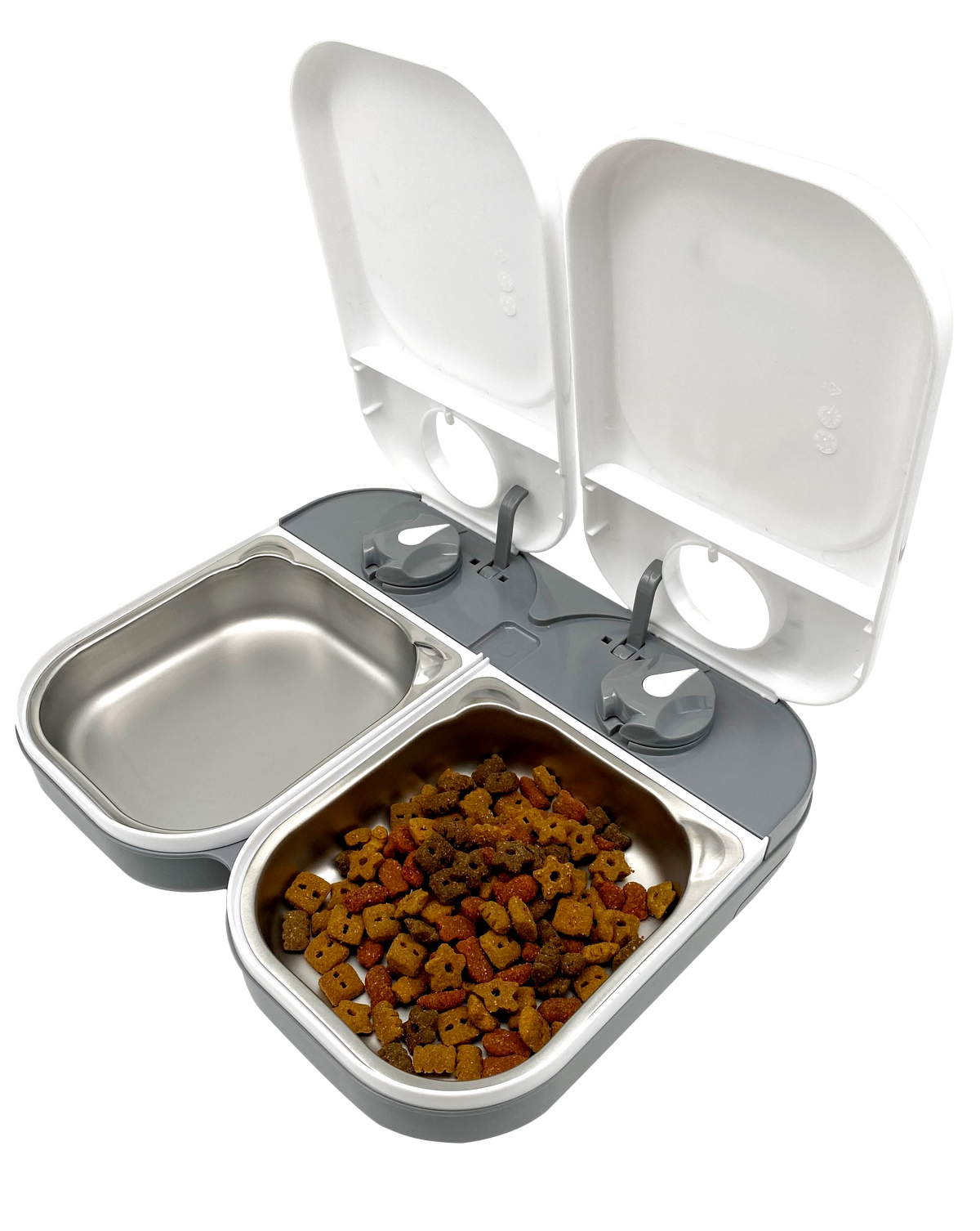 Double automatic pet feeder with two open white lids, each covering a separate stainless steel food bowl. One bowl is empty, and the other contains dry pet food. The feeder has a gray base with two mechanical dial timers for scheduled feeding